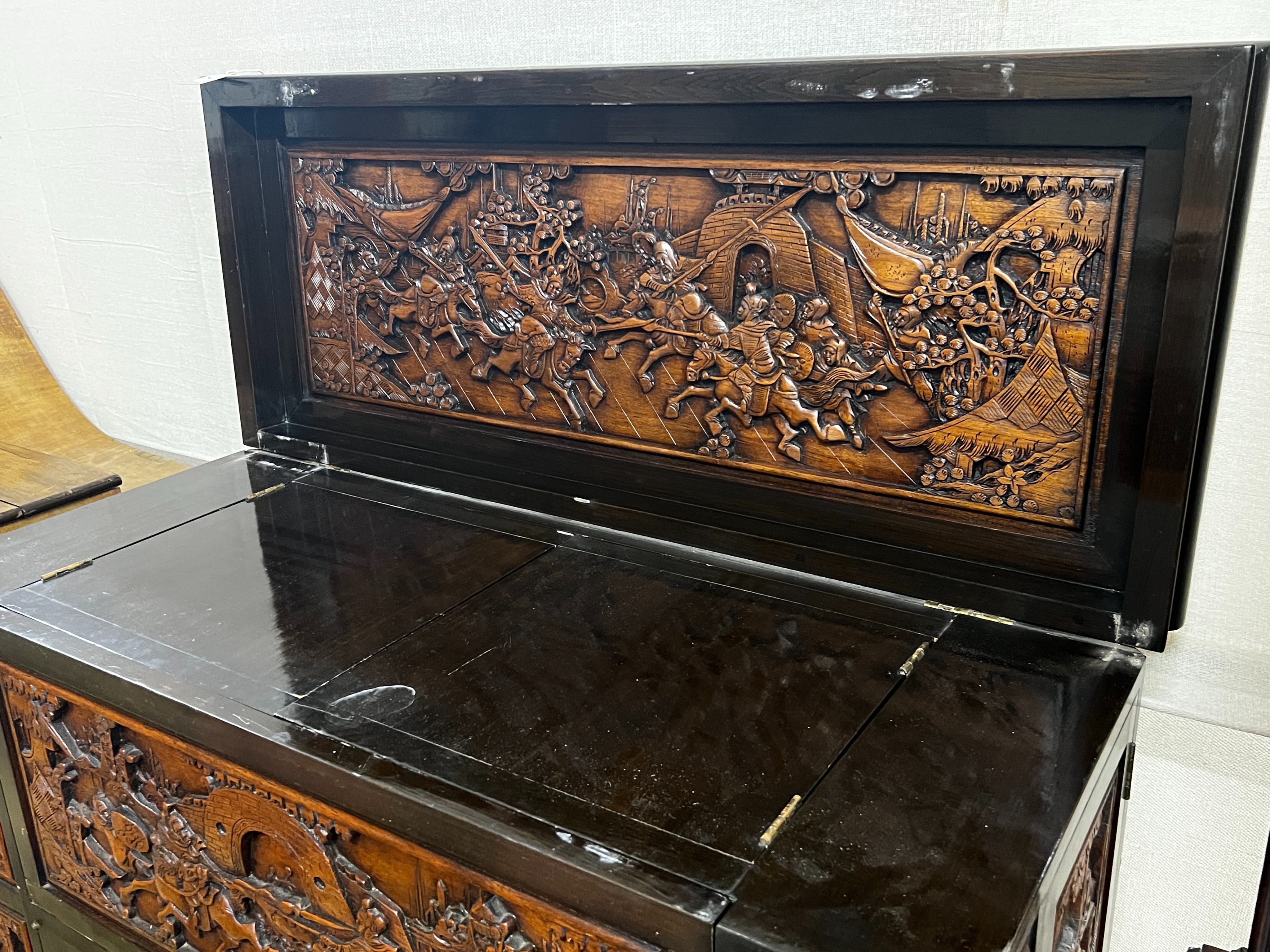 A Chinese carved hinged top cocktail cabinet with mirrored interior, width 111cm, depth 46cm, height 107cm